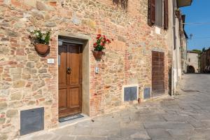 a brick building with a wooden door and flowers on it at Small Rustic Apartment in Scrofiano