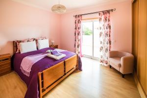 a bedroom with a bed and a chair and a window at Laguna Formosa in Faro