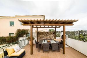 a pergola on a patio with a table and chairs at Laguna Formosa in Faro