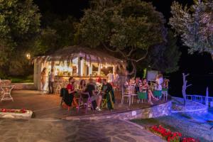 a group of people sitting on a deck at night at Menagia Village in Agios Georgios +166 photos