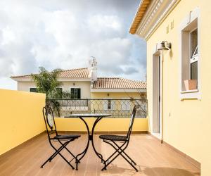a patio with two chairs and a table on a balcony at Laguna Formosa in Faro +35 photos