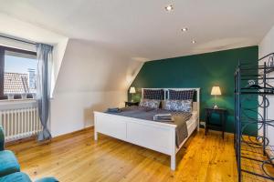 a bedroom with a bed and a green wall at My Cocoon in Lüdenscheid