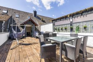 a patio with a table and chairs on a wooden deck at My Cocoon in Lüdenscheid