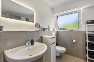 a bathroom with a sink and a toilet and a window at My Cocoon in Lüdenscheid +34 photos