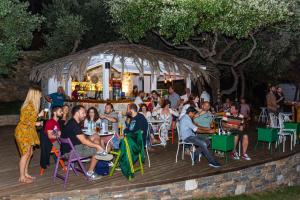 a group of people sitting at tables in a bar at Menagia Village in Agios Georgios