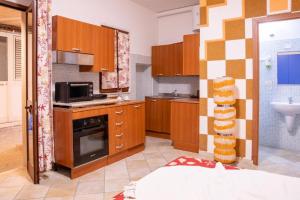 a kitchen with wooden cabinets and a microwave at B&B Pedruzza in Alghero