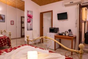 a bedroom with a bed and a desk and a television at B&B Pedruzza in Alghero