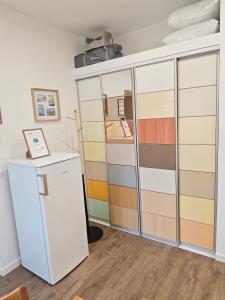 a room with a wardrobe and a refrigerator at La Maison de violette meublé classé 3 étoiles in Montdidier