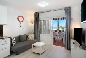 a living room with a couch and a tv at Casa Princesa in Playa del Cura