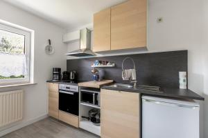 a kitchen with wooden cabinets and a black counter top at Niebüllhus in Niebüll