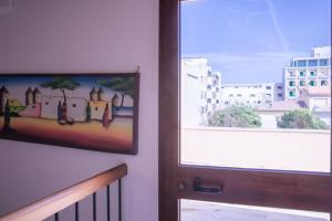 a door with a picture on the wall next to a window at B&B Pedruzza in Alghero