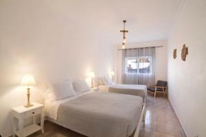 a bedroom with two beds and a cross on the wall at Âncora B in Monte Gordo