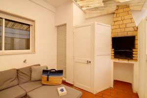 a living room with a couch and a tv at Âncora B in Monte Gordo