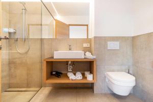 a bathroom with a sink and a toilet and a shower at Ferienwohnungen Karin - Gala in Termeno +19 photos