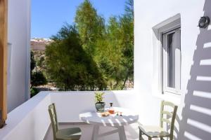a table and chairs on a balcony with a window at Echinousa Kimolos Maisonette no4 in Kimolos