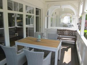 a porch with a wooden table and chairs at Apartment Juliusruh-6 by Interhome in Juliusruh +11 photos