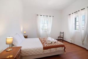 a white bedroom with a bed and two windows at Quinta Alegre Tavira T3 in Luz de Tavira +28 photos