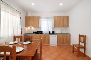 a kitchen and dining room with a wooden table and chairs at Quinta Alegre Tavira T3 in Luz de Tavira