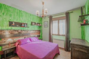 a bedroom with a pink bed and green walls at Casa Las Tres Coteras in Muñopedro