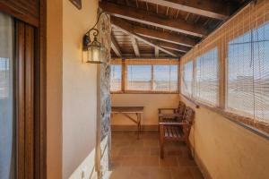 a hallway with a table and windows in a house at Casa Las Tres Coteras in Muñopedro