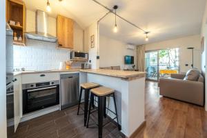 a kitchen and living room with a counter and stools at Apartamentos Salou - 112 in Salou