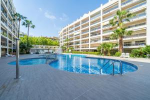 a swimming pool in front of a large apartment building at Apartamentos Salou - 112 in Salou