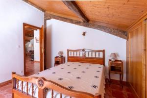 a bedroom with a wooden bed and a wooden ceiling at Maison Yaitua in Esterençuby