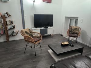 a living room with two chairs and a television at Chez nono et vero in Roussillon en Isere