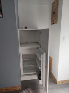 an empty refrigerator with its door open in a room at Chez nono et vero in Roussillon en Isere
