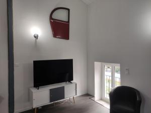 a living room with a flat screen tv on a white wall at Chez nono et vero in Roussillon en Isere +27 photos
