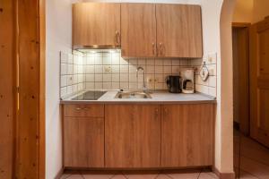 a kitchen with wooden cabinets and a sink at Sonnenparadies Apartement 4 in Saltusio +13 photos