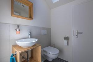 a bathroom with a sink and a toilet at Ferienwohnung Linde in Taching am See +17 photos