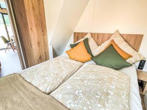 a bed with pillows on it in a room at Holiday Home Tiny Haus Glockenalm-EiblChalet by Interhome in Aurach