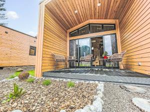 a house with a patio with chairs on it at Holiday Home Tiny Haus Glockenalm-EiblChalet by Interhome in Aurach