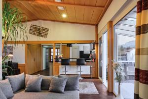 a living room with a couch and a kitchen at Ferienhaus am Millibach in Wehingen