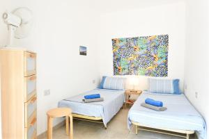a room with two beds and a painting on the wall at Appartamento Pini in Cala Gonone