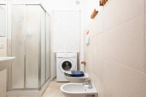 a bathroom with a washing machine and a washer and dryer at Appartamento Pini in Cala Gonone