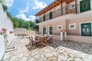 a patio of a house with a table and chairs at Spyridoula Studio 11 in Paleokastritsa