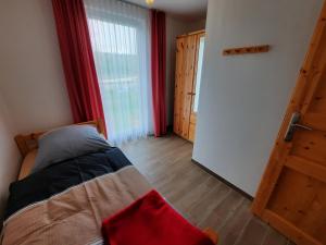 a bedroom with a bed and a door to a room at Ferienhaus Emelie Geiseltalsee in Mücheln