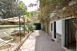 a walkway leading to a building with chairs and trees at Appartamento Pini in Cala Gonone