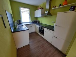 a small kitchen with white appliances and a window at Ferienhaus Emelie Geiseltalsee in Mücheln