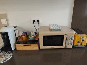 a microwave sitting on top of a table at La Maison de violette meublé classé 3 étoiles in Montdidier +10 photos