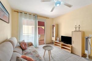 a living room with a couch and a tv at Sol y Mar in Puerto de Santiago