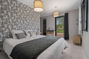 a bedroom with a large bed with a wall at Les loges de Pérelle in Chozeau
