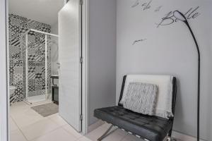 a black chair in a white room with a lamp at Les loges de Pérelle in Chozeau +37 photos