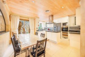 a kitchen with a large wooden table and chairs at Villa Cala Llamp in Port d'Andratx