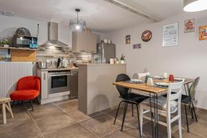 a kitchen with a table and chairs in a room at Les loges de Pérelle in Chozeau