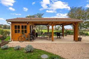 a wooden gazebo with a bike parked in it at Les loges de Pérelle in Chozeau
