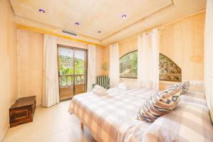a bedroom with a large bed and a window at Villa Cala Llamp in Port d'Andratx +37 photos