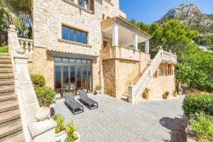 a stone house with two chairs and a staircase at Villa Cala Llamp in Port d'Andratx